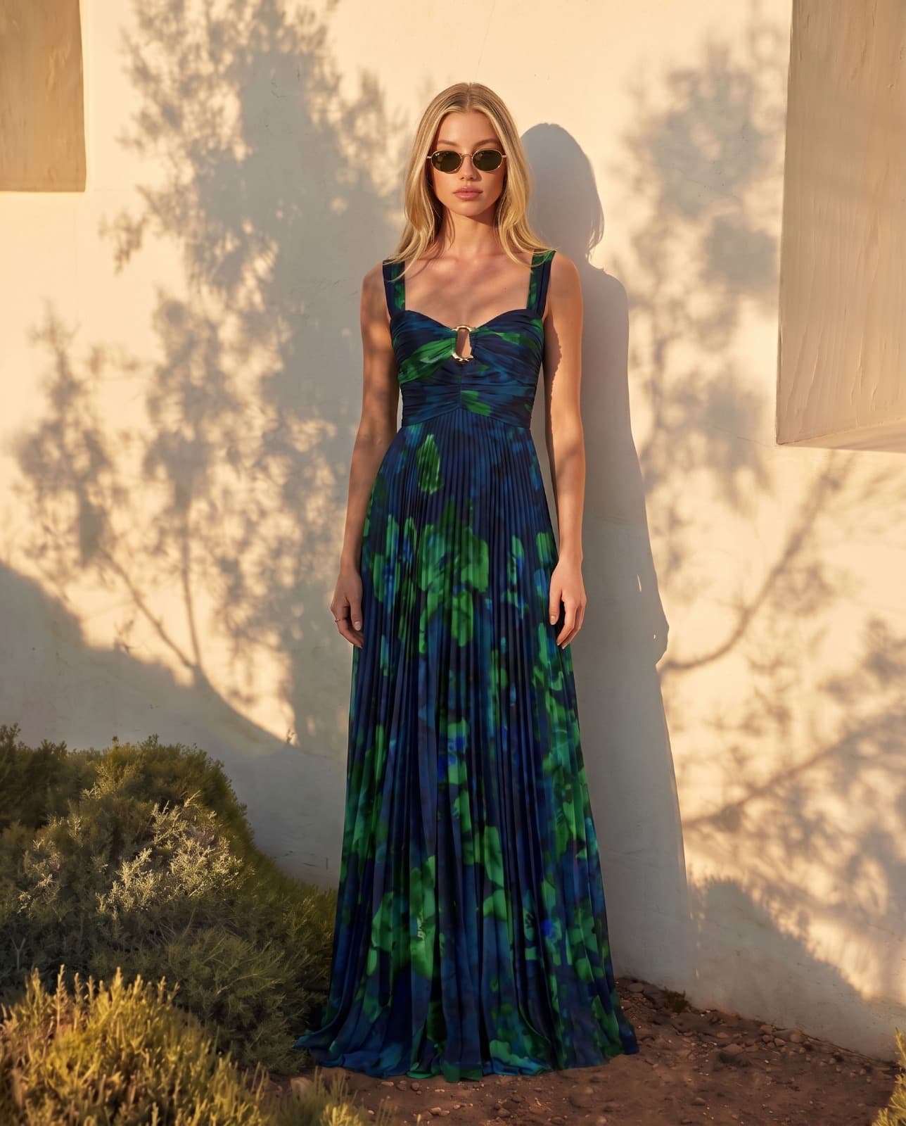 Woman in blue floral pleated gown, architectural wall