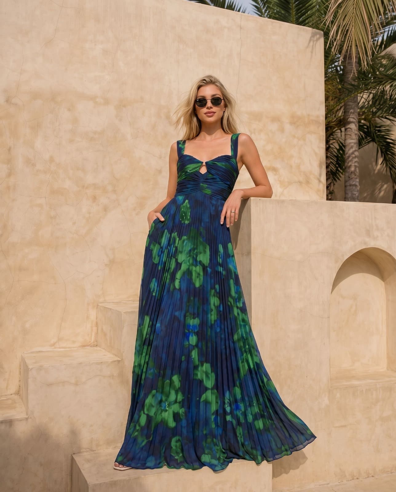 Woman in blue floral pleated gown on steps