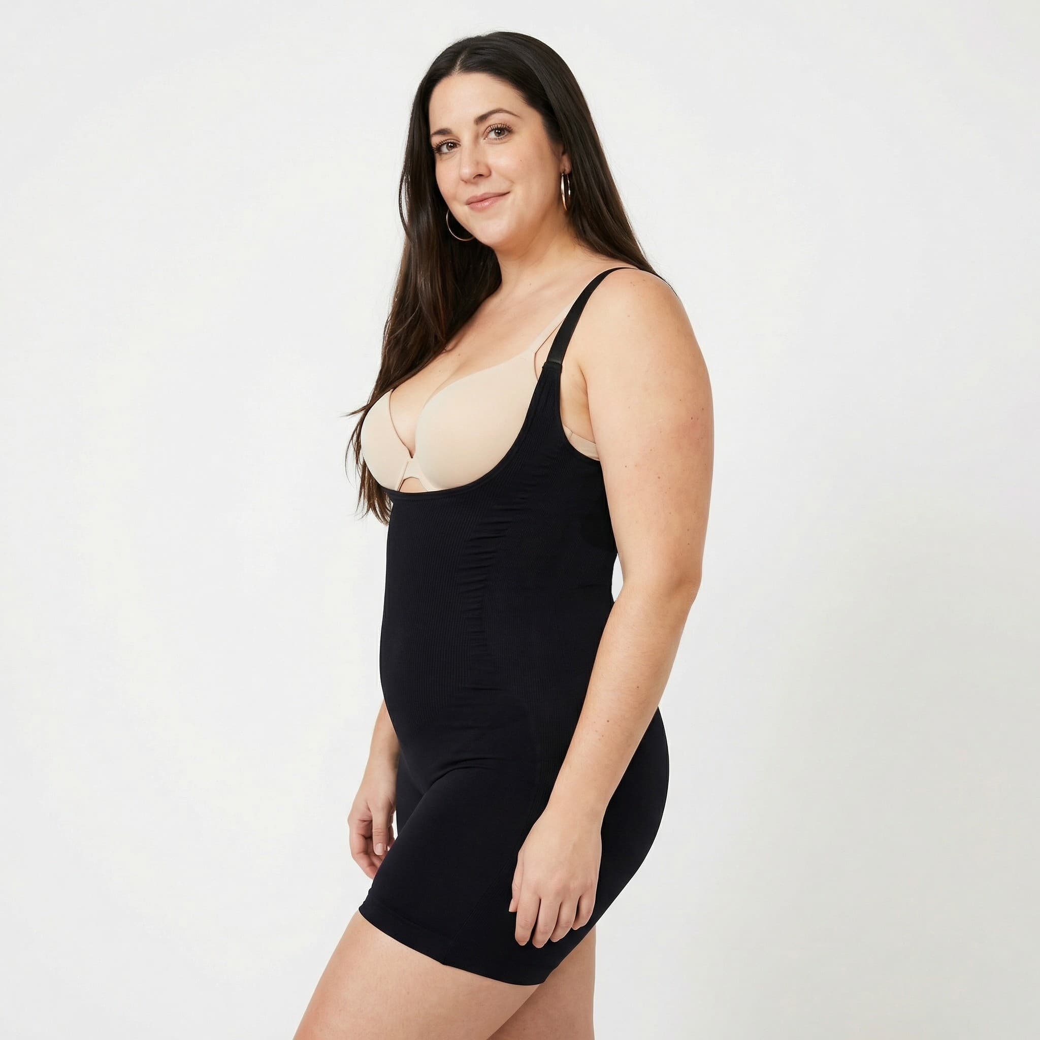 Woman in black ribbed bodysuit, studio side view